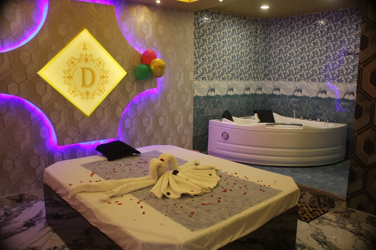 Dream Premium Spa Jacuzzi suite — private hydrotherapy tub with rose petal bed and illuminated D logo
